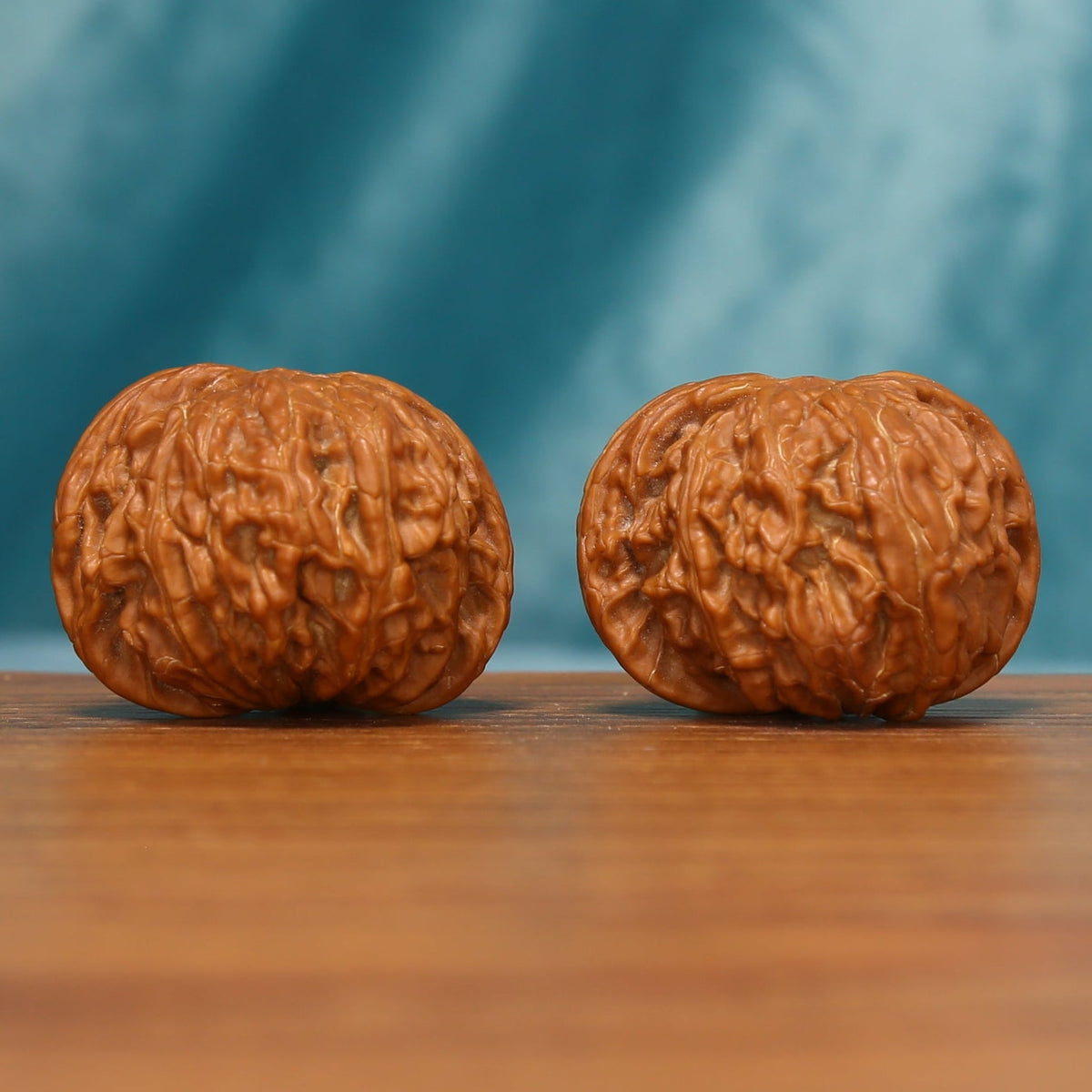 Millstone Wenwan walnut pair shown from a front-left angle with broad rounded forms
