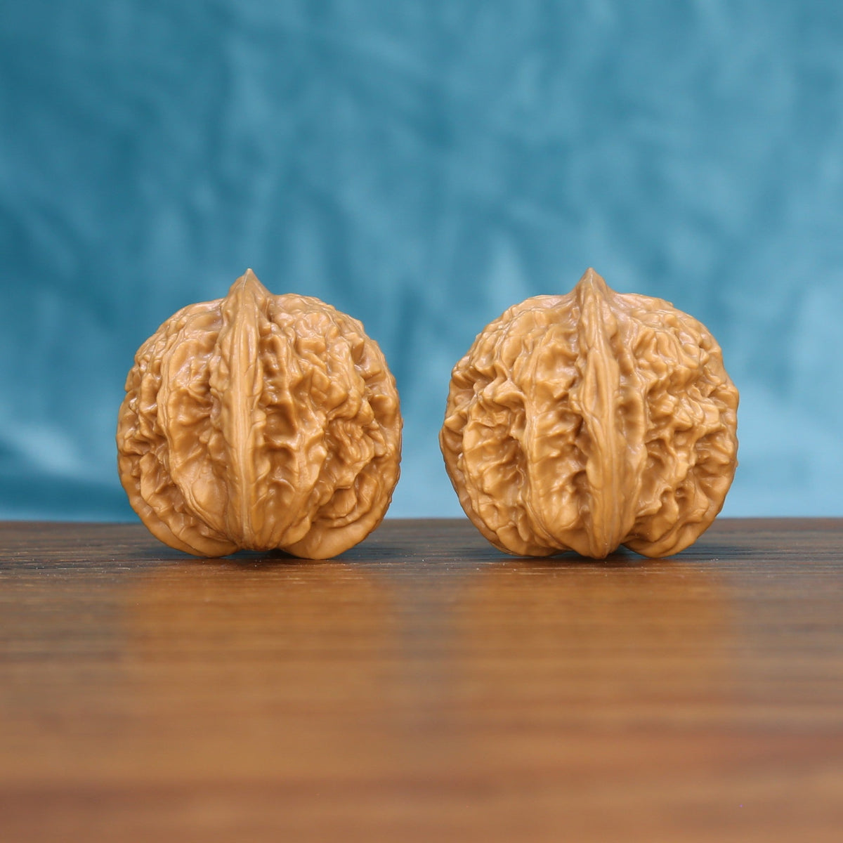 Three-quarter view of two Coiling Dragon Wenwan walnuts showing detailed shell texture
