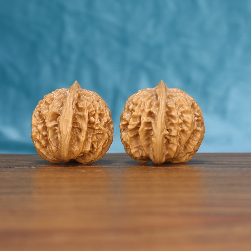 Side view of a Coiling Dragon Wenwan walnut pair on a wooden surface
