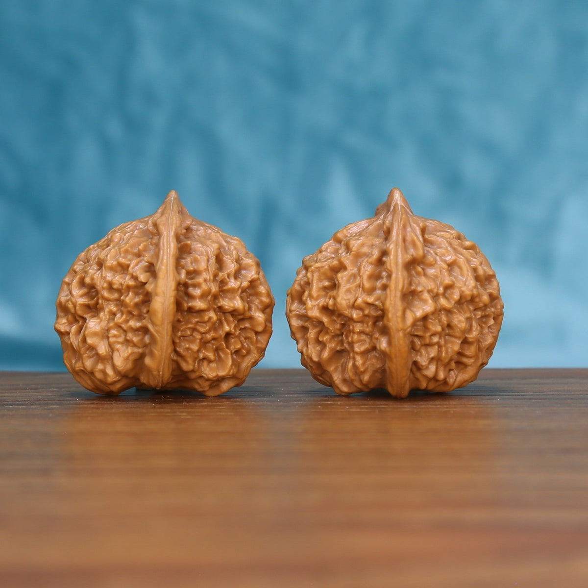 Close view of two matched Qinhuangdao Ingot wenwan walnuts showing deep ridges and warm natural grain
