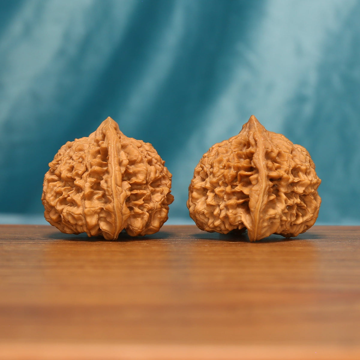 Side view of The Scholar's Crown Wenwan Walnut Set showing the walnuts’ capped profiles and dense ridge patterns.
