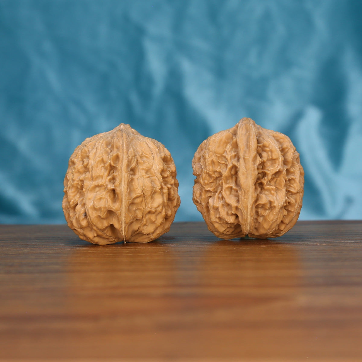 Xi-Bei Jiang-Jun-Bang wenwan walnut pair alternate angle, blue background – symmetrical frontier crest pattern