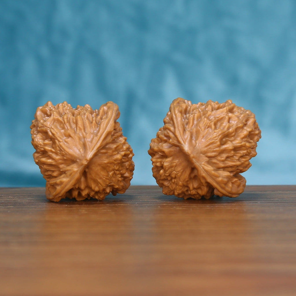 Side profile of the 6099 Qinhuangdao Ingot wenwan walnut pair showing the winged edge ridges
