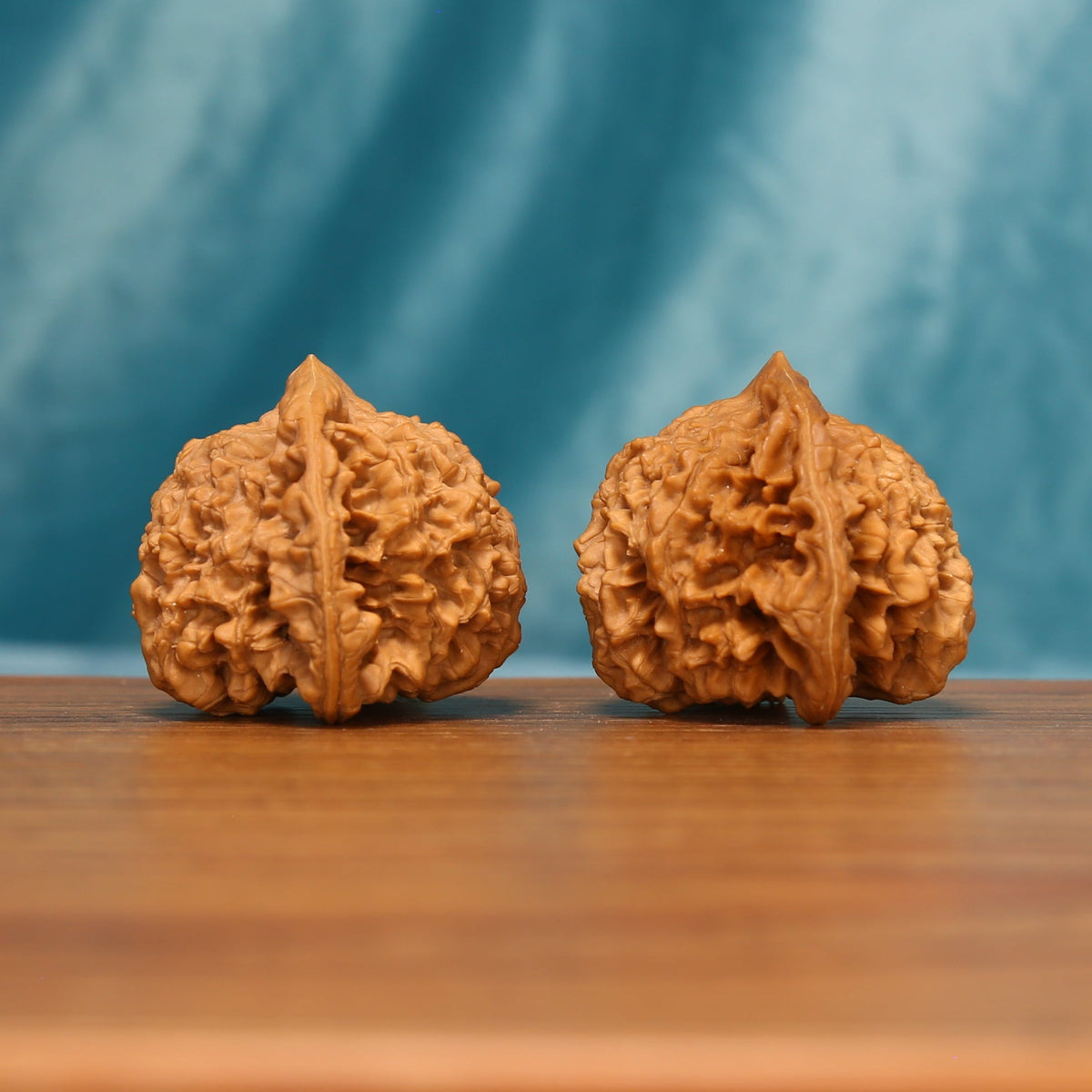 Detailed side view of The Scholar's Crown Wenwan walnuts with pronounced vertical ridges and sculpted surfaces.
