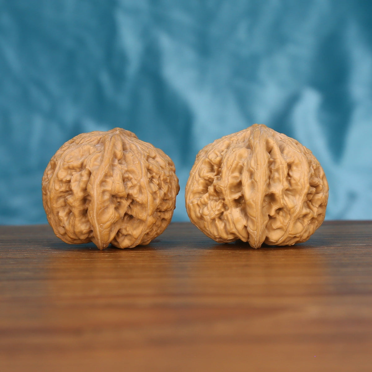Da-Cu-Jin wenwan walnut pair alternate angle, blue background – symmetrical earthborn monolith ridge pattern