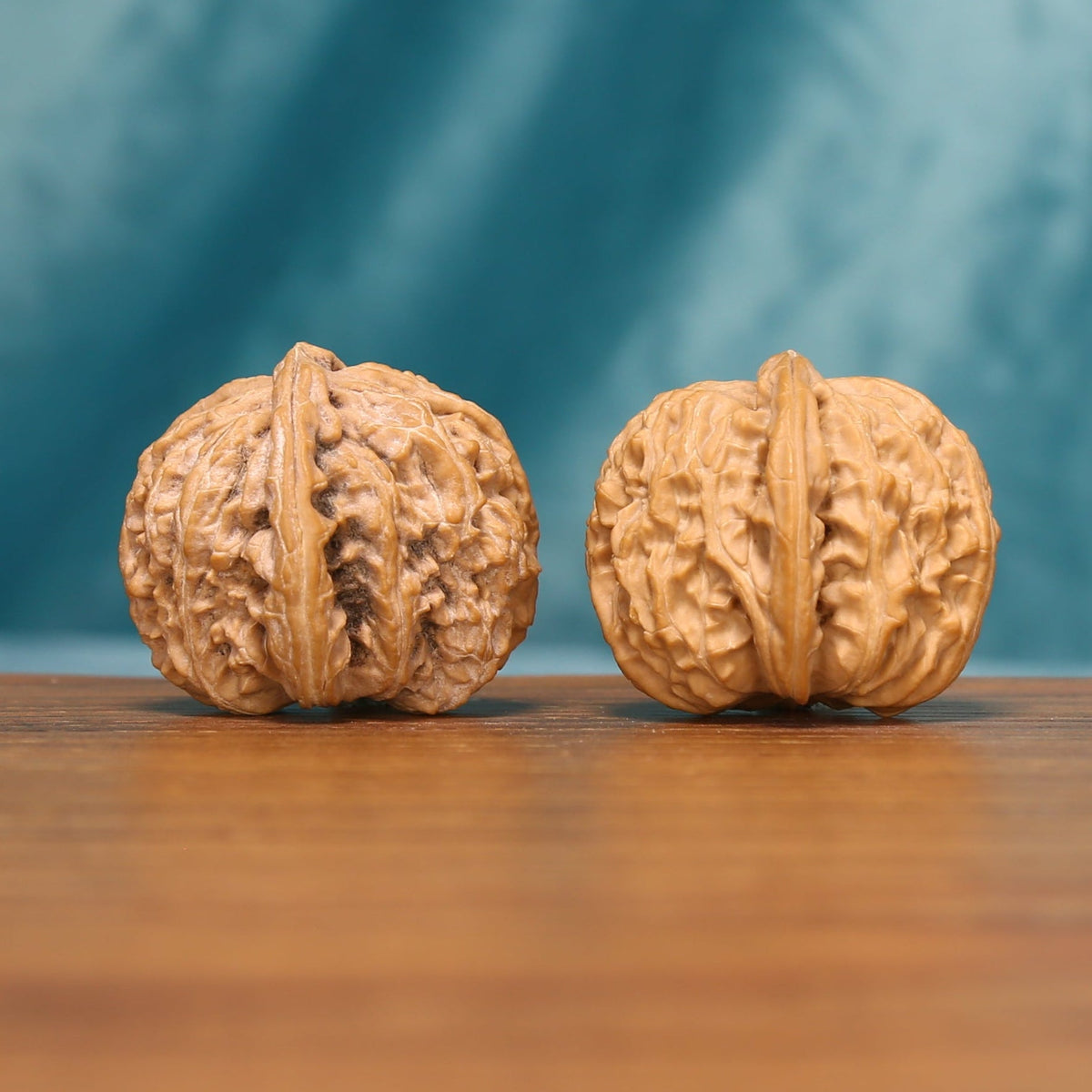 Detailed side view of The Ivory Roar Wenwan walnuts with pronounced vertical ridges and natural variation.
