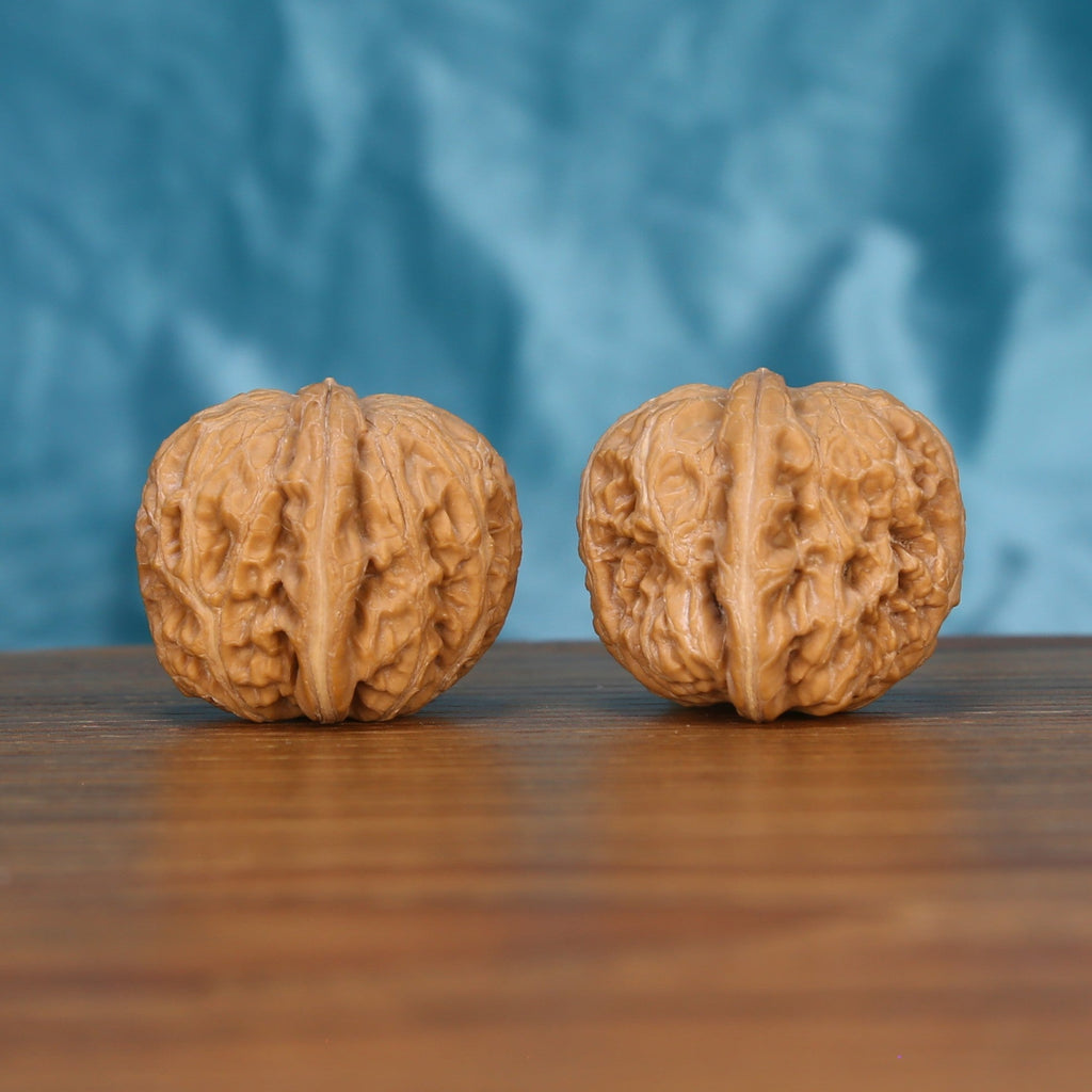 Single Ping-Gu-Yuan-Bao wenwan walnut on wooden surface, blue background – yuan-bao curved natural texture