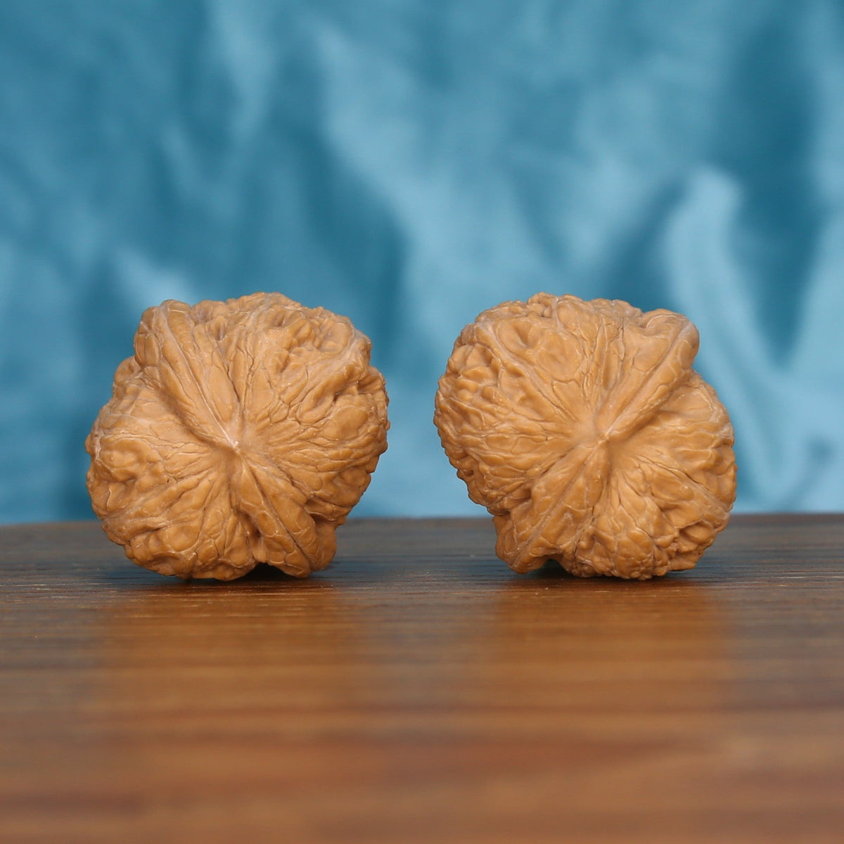 Single Ping-Gu-Yuan-Bao wenwan walnut bottom view on wooden surface – natural base and curved texture detail