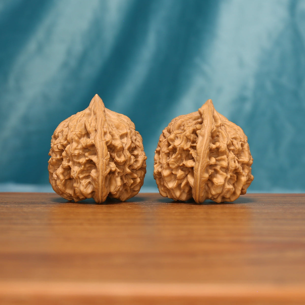 Side view of The Scholar's Cap Wenwan Walnut Set showing the walnuts’ capped profiles and dense ridge patterns.

