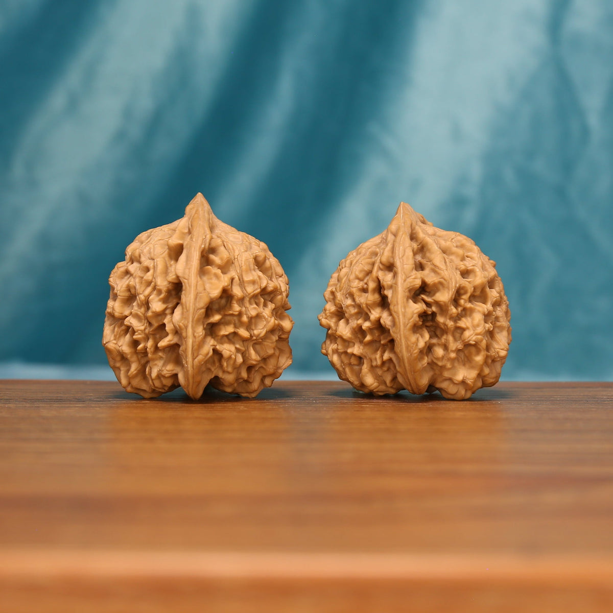 Detailed side view of The Scholar's Cap Wenwan walnuts with pronounced vertical ridges and sculpted natural surfaces.
