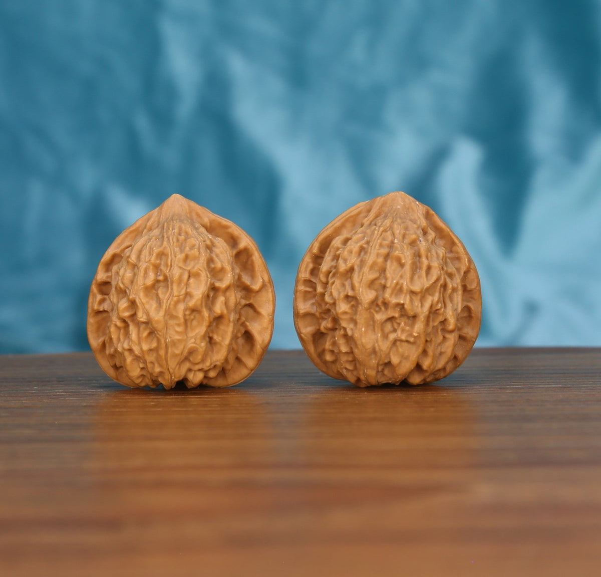 Xiao-Jin-Niu walnut set side profile on wood, blue background – untamed golden bull ridge grain detail
