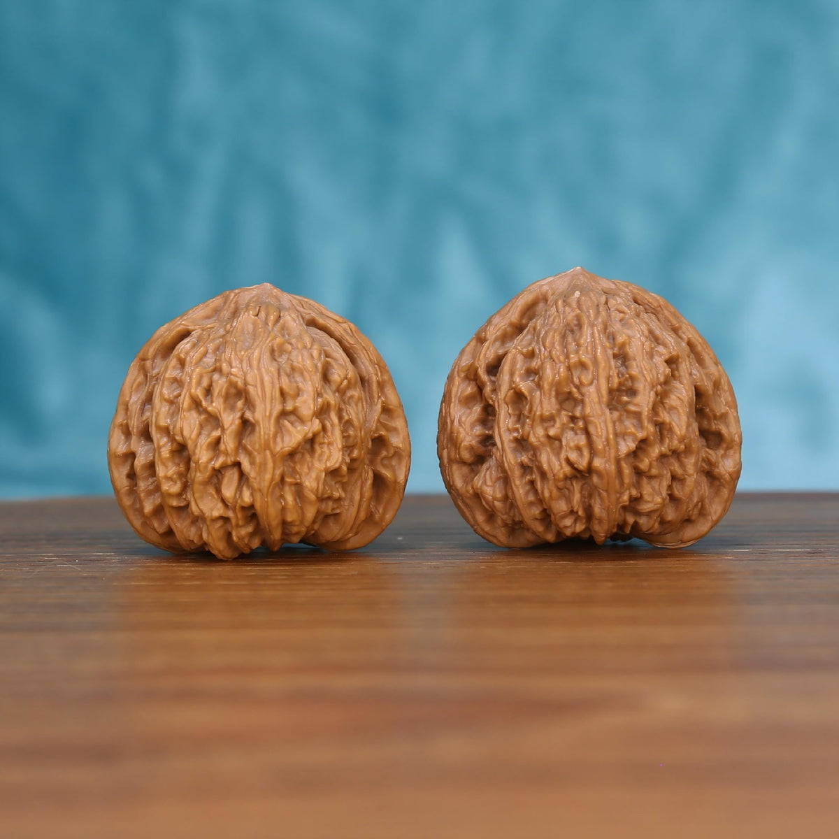 Two Wu-Ming wenwan walnuts on wooden surface, blue fabric background – matching mountain echo nameless set