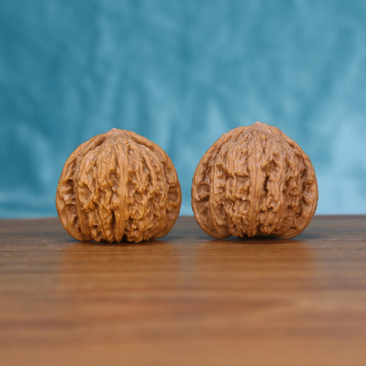 Wu-Ming walnut set side profile on wood, blue background – mountain echo natural grain detail