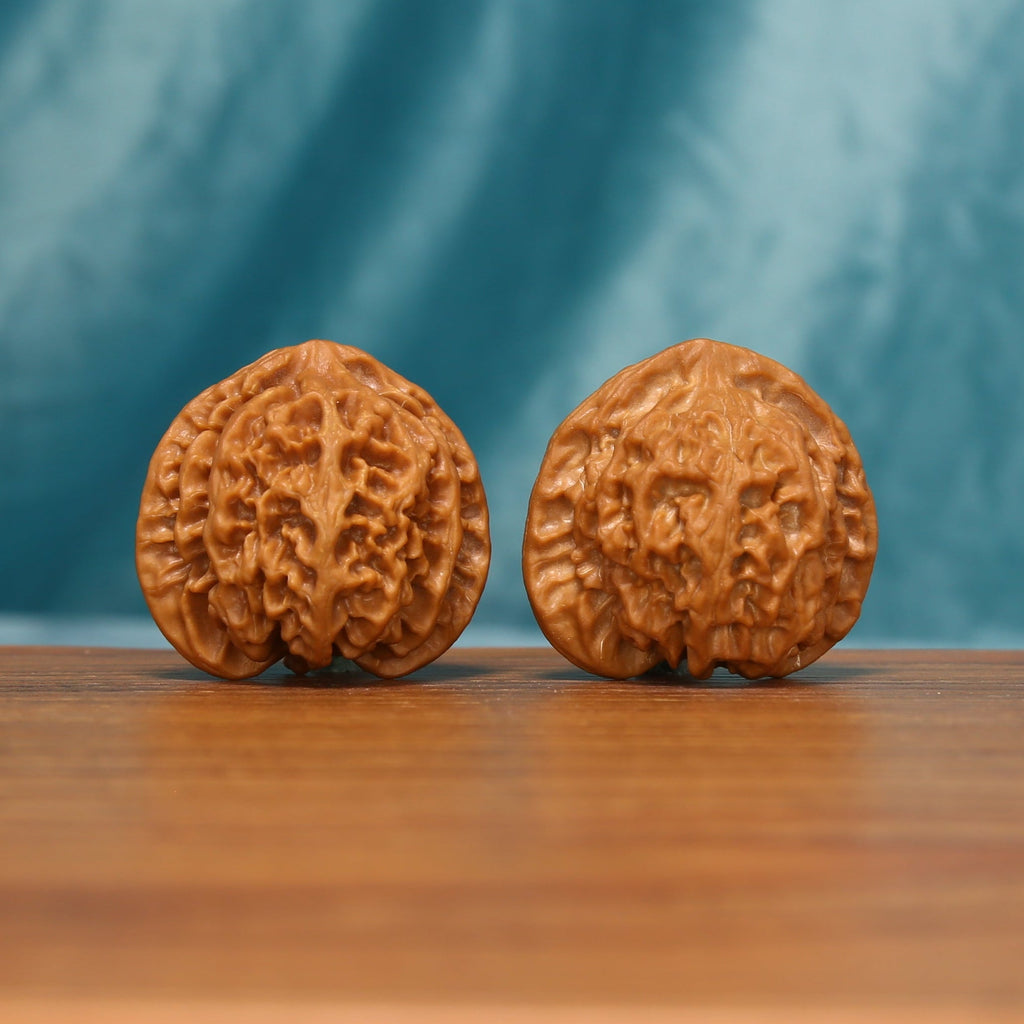 Apple Orchard Wenwan walnut pair showing the rounded carved surfaces from an angled view
