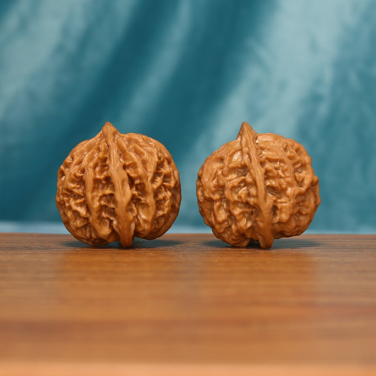 Apple Orchard Wenwan walnut pair shown from the side with detailed textured carving
