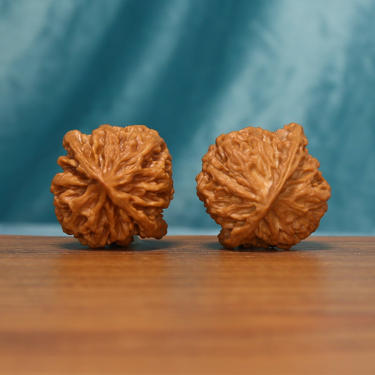 Apple Orchard Wenwan walnut pair showing the rear contours and carved ridge patterns
