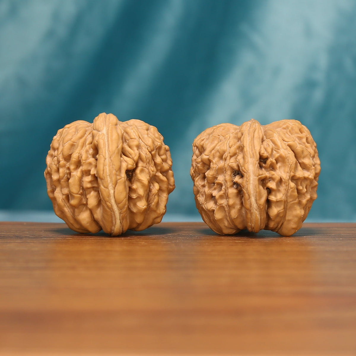 Close view of the Huakun Dragon Wenwan walnut pair highlighting the deep textured grooves
