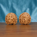 Two Ping-Guo-Yuan wenwan walnuts on wooden surface, blue fabric background – matching balanced solitude set