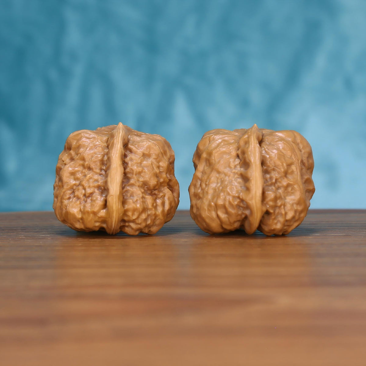 Yi-Dao-Jin walnut pair on rosewood stand – singular ridge silhouette in traditional display setting
