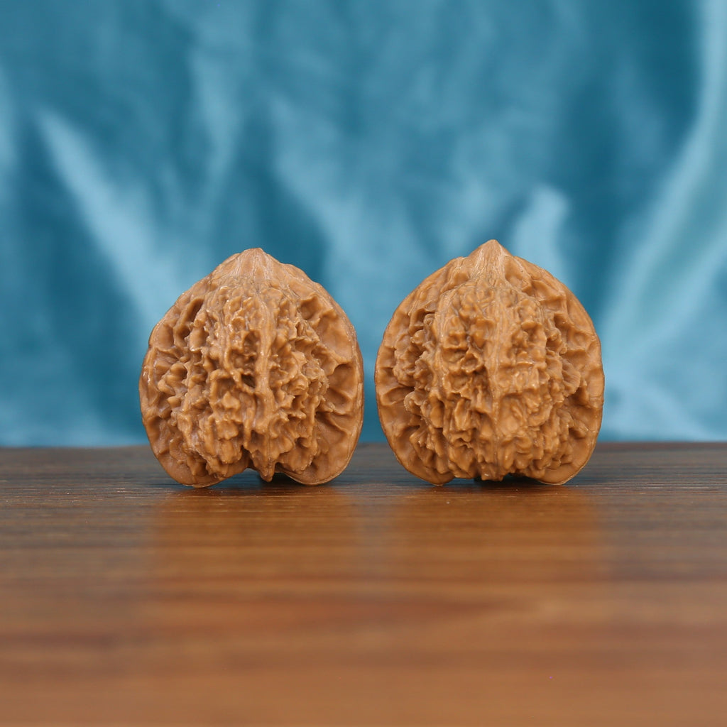 Man-Tian-Xing walnut set side profile on wood, blue background – star-pattern constellation grain detail