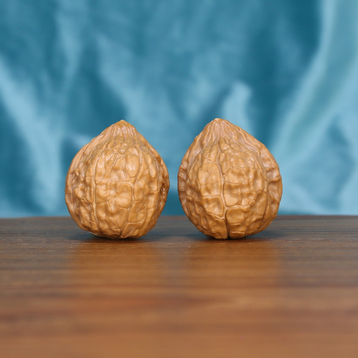 Two Gui-Jia-Wen wenwan walnuts on wooden surface, blue fabric background – matching ancient shield set