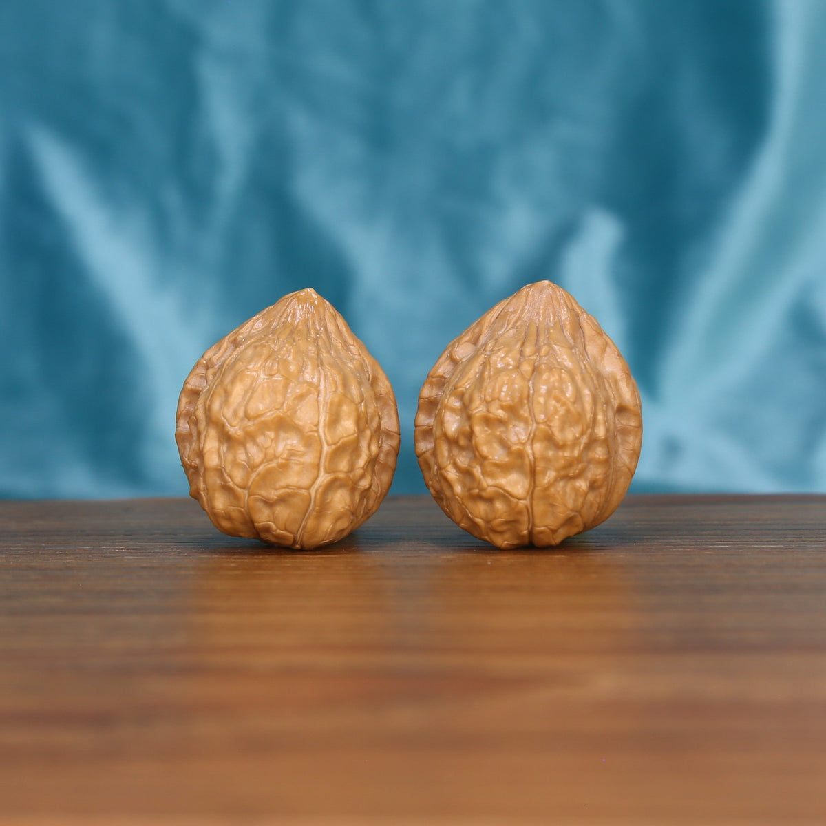 Gui-Jia-Wen walnut set side profile on wood, blue background – ancient shield hexagonal grain detail