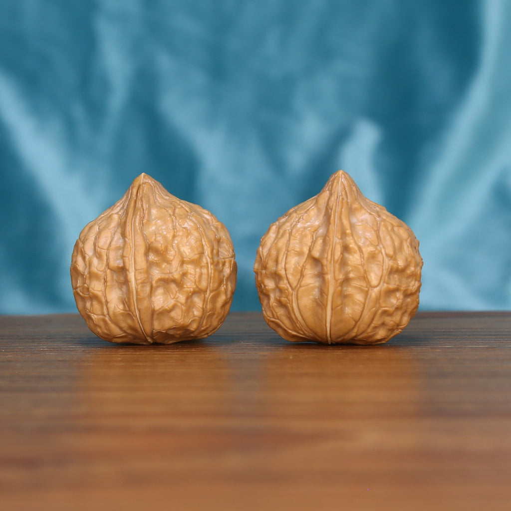 Single Gui-Jia-Wen wenwan walnut on wooden surface, blue background – intricate tortoise shell natural texture