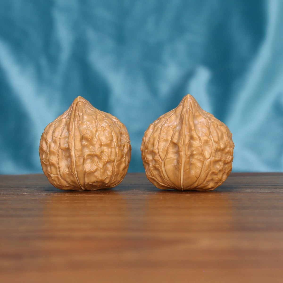 Single Gui-Jia-Wen wenwan walnut on wooden surface, blue background – intricate tortoise shell natural texture