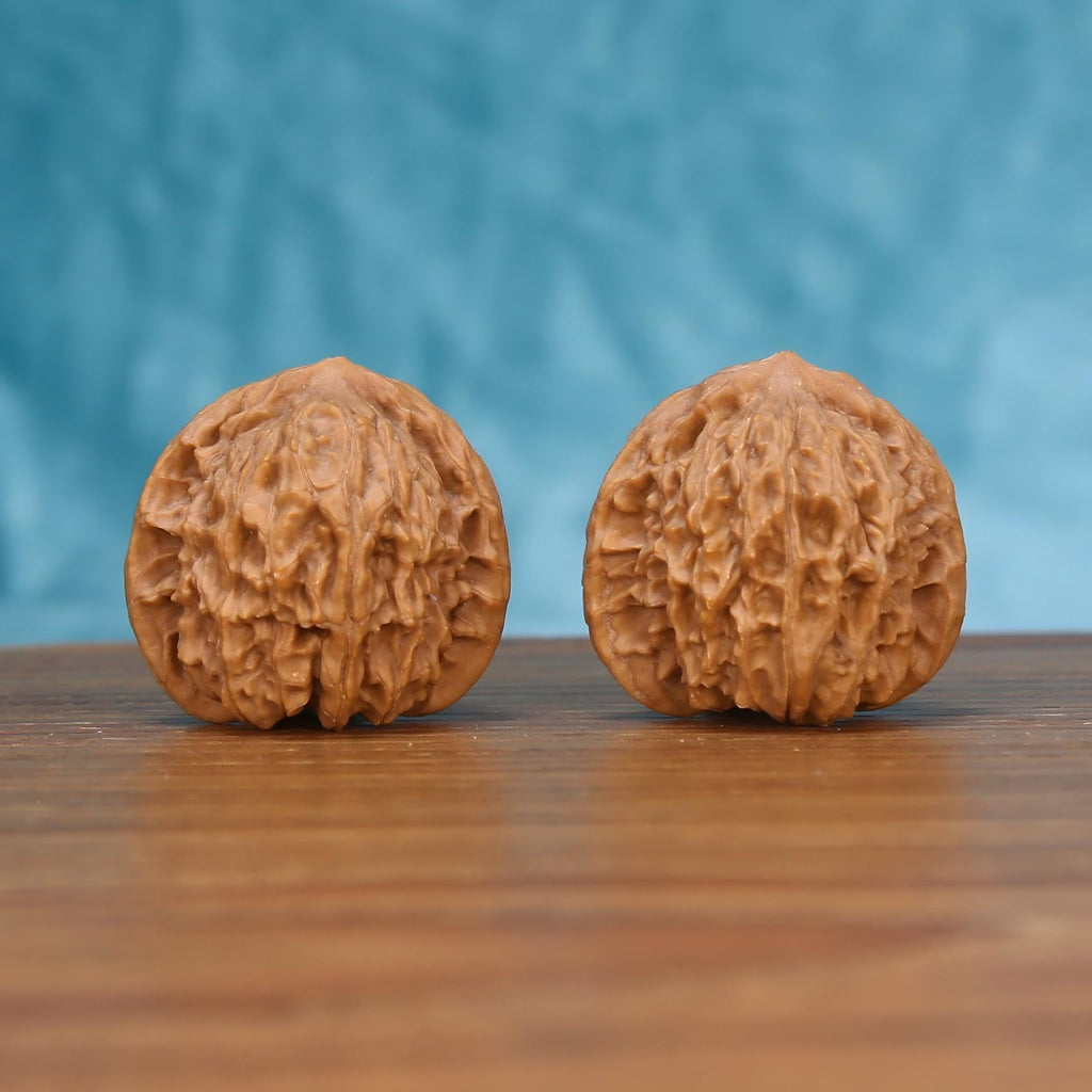 Two Hong-Dou wenwan walnuts on wooden surface, blue fabric background – matching tectonic ridge set