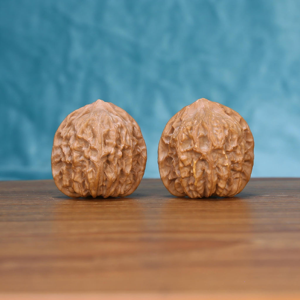 Jiang-Jun-Bang walnut set side profile on wood, blue background – general's armor plated grain detail