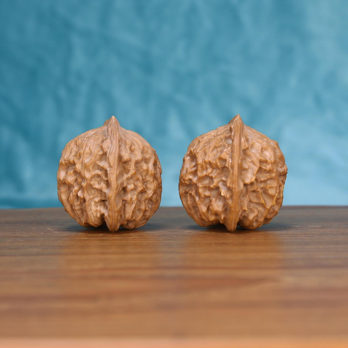 Single Jiang-Jun-Bang wenwan walnut on wooden surface, blue background – bold general's armor natural texture close-up