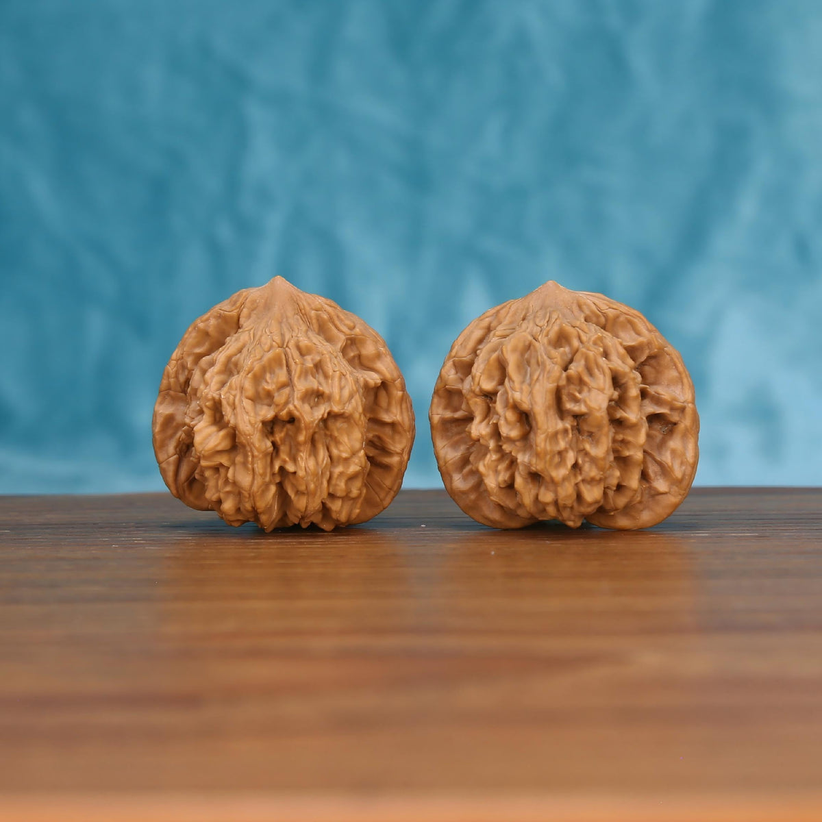  Two Mai-Sui-Hu-Tou wenwan walnuts on wooden surface, blue fabric background – matching primal crest set