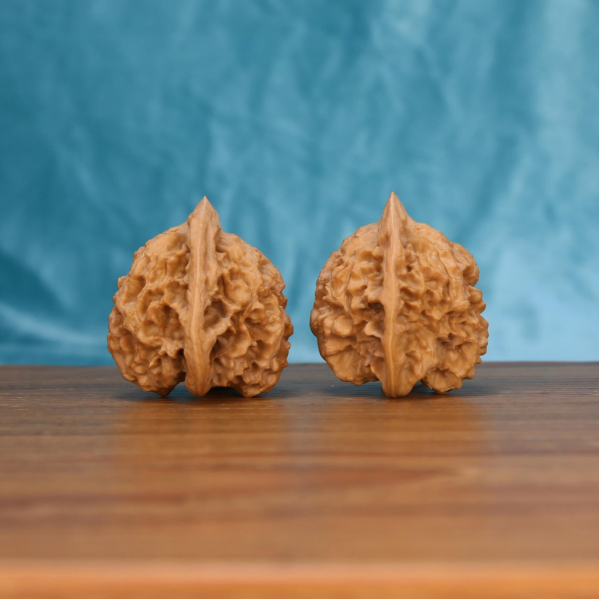 Qi-Lin-Wen Guan-Mao wenwan walnut pair alternate angle, blue background – symmetrical mythic crest ridge pattern