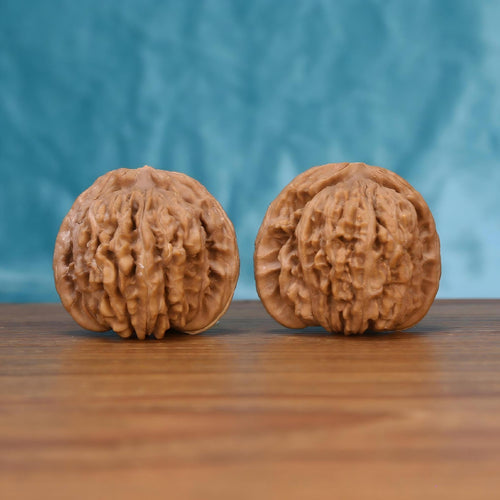 Two Si-Zuo-Lou wenwan walnuts on wooden surface, blue fabric background – matching sovereign pavilion set