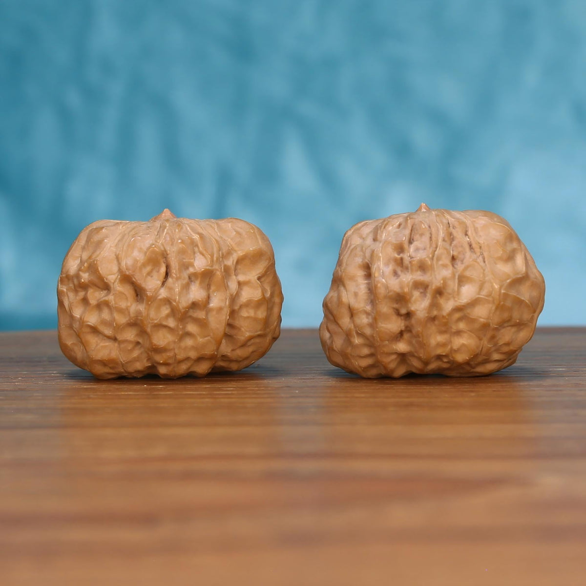 Yi-Dao-Jin walnut set side profile on wood, blue background – single golden blade ridge grain detail